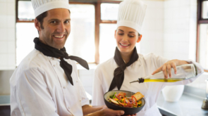 happy-chef-pouring-olive-oil-salad_107420-37654